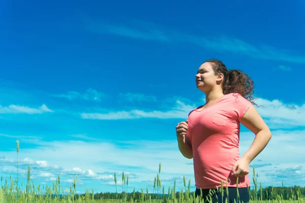 Young woman jogging in wide field — Stock Photo, Image