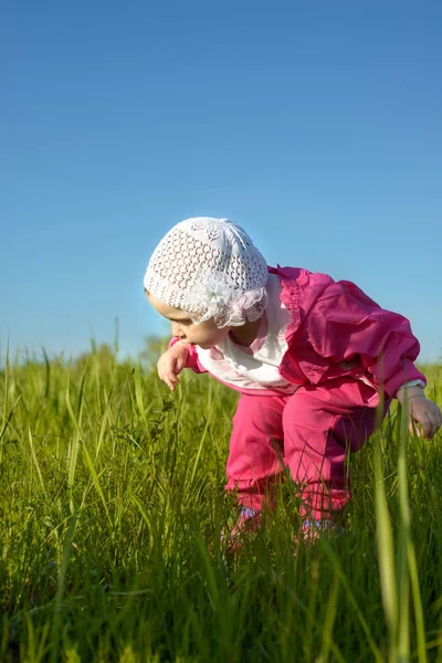 Klein meisje in het groene gras — Stockfoto