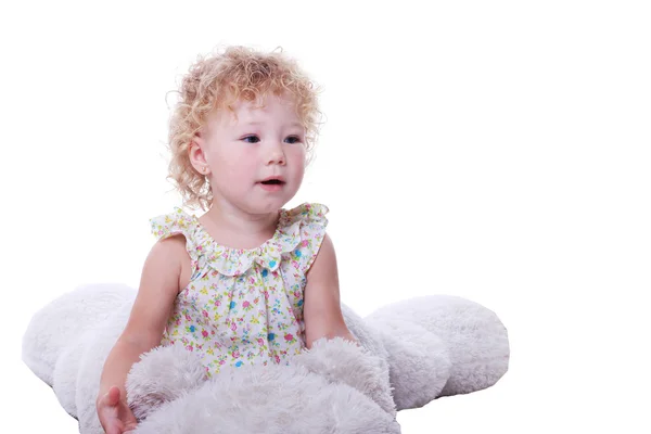 Cute baby siting on the white bear and looking interested in something — Stock Photo, Image