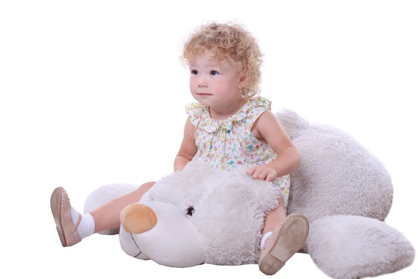 Cute baby siting on the white bear and looking interested in something — Stock Photo, Image