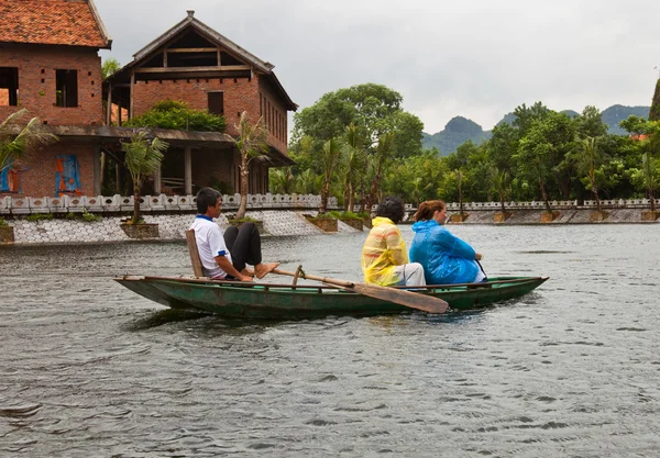 越南裔男子给两名游客乘船游览 — 图库照片