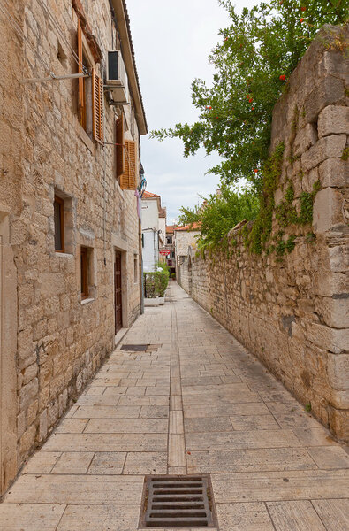Narrow street with medieval houses in the historical center of Trogir, Croatia. World Heritage site of UNESCO