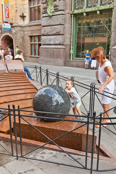 Niño rueda bola de granito —  Fotos de Stock