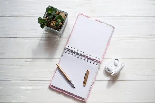 白色木制桌子上的笔记本和钢笔 图库图片