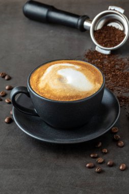 Kahveyi siyah porselen bardakta taştan masada dinlendiriyorum.