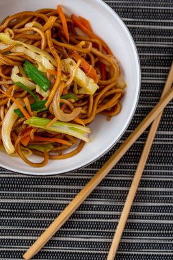 Siyah beyaz arka planda sebzeli vejetaryen erişte kasesi.