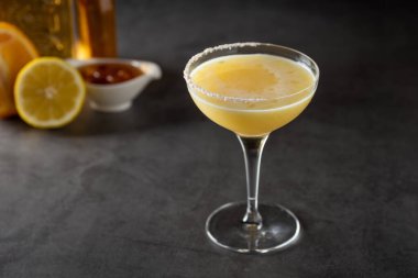 Limonlu ve tekilalı lüks kokteyl koyu taşlı arka planda.