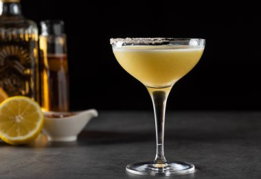 Limonlu ve tekilalı lüks kokteyl koyu taşlı arka planda.