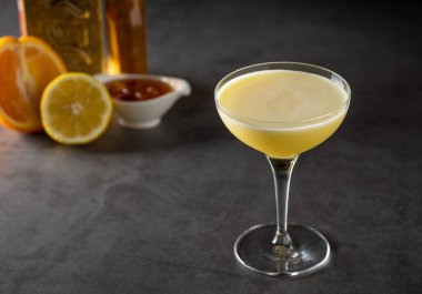 Limonlu ve tekilalı lüks kokteyl koyu taşlı arka planda.
