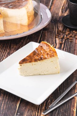 Tahta masada kahve ile dilimlenmiş San Sebastian peynirli keki.