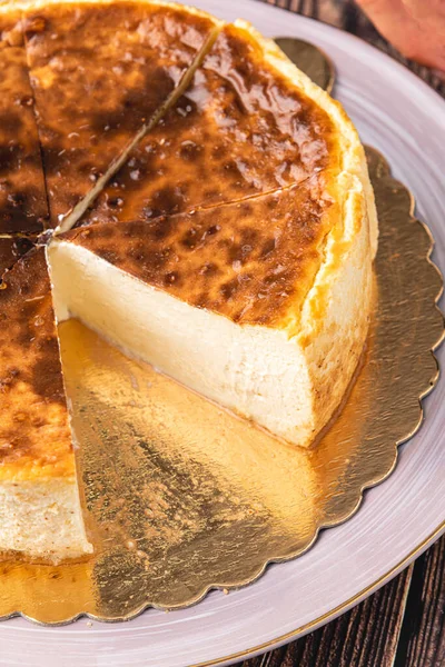 木製のテーブルの上にコーヒーとスライスサンセバスチャンチーズケーキ — ストック写真