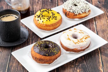 Ahşap masada farklı süslerle süslenmiş lezzetli çörekler.