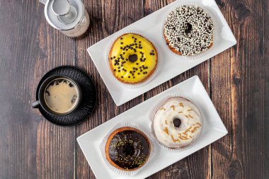 Ahşap masada farklı süslerle süslenmiş lezzetli çörekler.