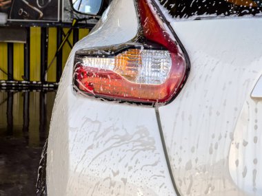 Köpükle yıkanan arabanın üzerinden sabun köpükleri akıyor.