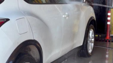 Çamaşır makinesi kirli arabayı yüksek basınçlı suyla yıkar. Kirli araba temiz suyla temizlenir.