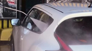 Çamaşır makinesi kirli arabayı yüksek basınçlı suyla yıkar. Kirli araba temiz suyla temizlenir.