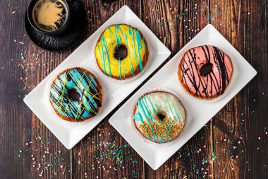 Ahşap masada farklı süslerle süslenmiş lezzetli çörekler.