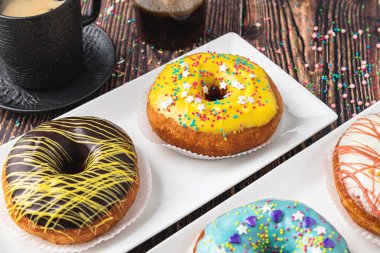 Ahşap masada farklı süslerle süslenmiş lezzetli çörekler.