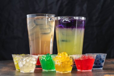 Koyu ahşap arka planda köpüklü çay ile limonata.