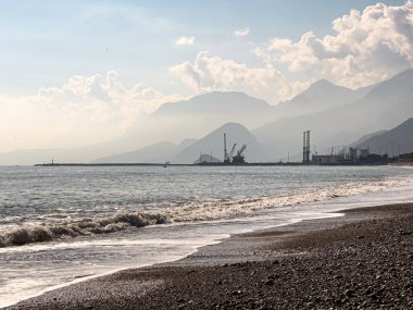 Önünde kumsal, arkasında dağlar olan kargo limanı..