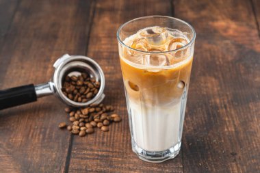 Kahve dükkanındaki ahşap bir masaya buz küplü buzlu Latte kahve.