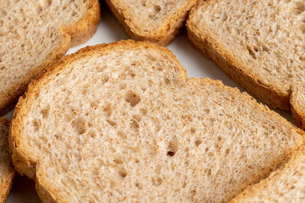 白い皿の上に小麦粉から焼き上げた茶色のパンのスライス — ストック写真