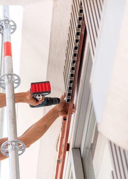 İşçi vidayı binanın plastik kaplamasına vidaladı