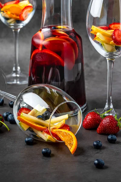 暗い石のテーブルの上に赤いサングリアと果物のガラス — ストック写真