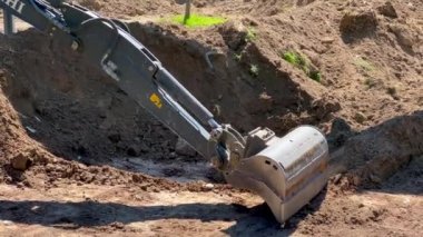 Mini kazıcı toprağı kazıyor ve toprağı düzleştiriyor. 4k ağır çekim görüntüleri