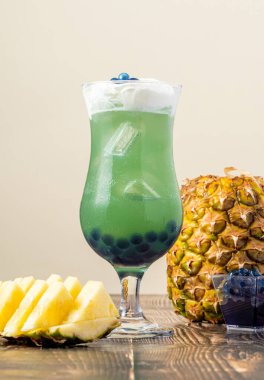 Koyu arkaplanda cam bardakta meyveli baloncuk çayı.