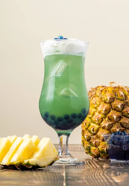 Koyu arkaplanda cam bardakta meyveli baloncuk çayı.