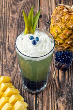 Koyu arkaplanda cam bardakta meyveli baloncuk çayı.