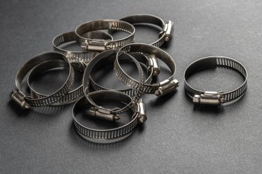 Siyah arka planda metal hortum kıskacı. Metin için boş boşluk