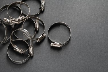 Siyah arka planda metal hortum kıskacı. Metin için boş boşluk