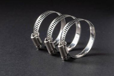 Siyah arka planda metal hortum kıskacı. Metin için boş boşluk