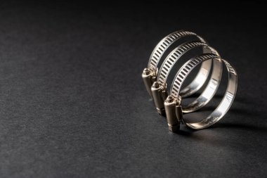 Siyah arka planda metal hortum kıskacı. Metin için boş boşluk