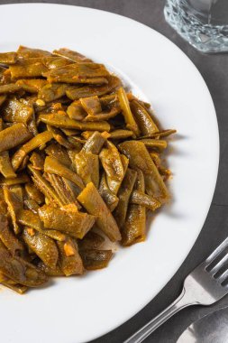 Green beans with olive oil on a white porcelain plate. Healthy eating concept