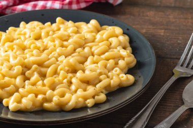 Delicious Mac n Cheese or macaroni and cheese on a black porcelain plate