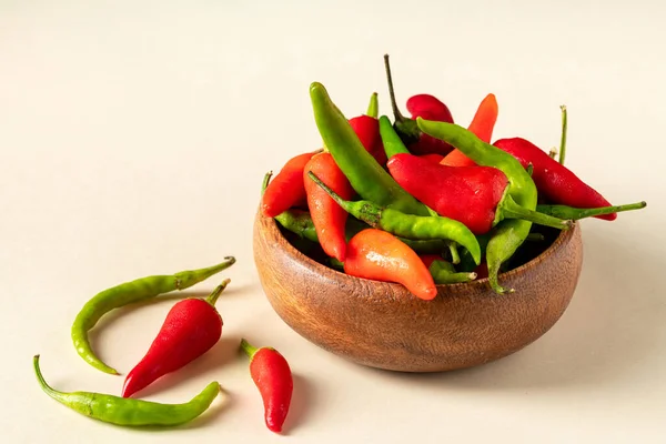 Organic fresh red and green hot peppers in wooden bowl