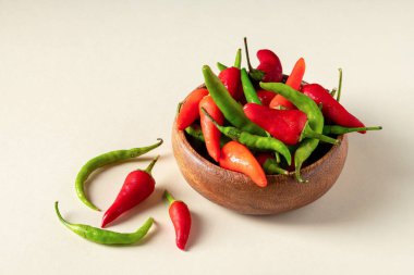 Organic fresh red and green hot peppers in wooden bowl