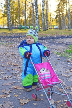 bir oyuncak bebek arabası ile çocuk
