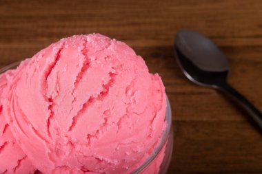 Arka planda bulanık bir kaşıkla çilek aromalı dondurma. Yakın çekim fotoğrafçılık.