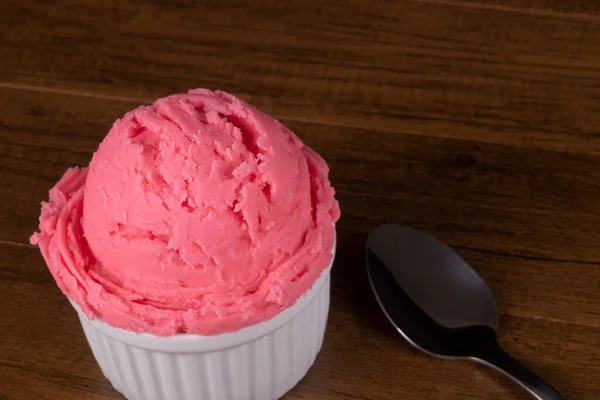 Strawberry flavored ice cream served in a white pot. Gastronomic photography of ice cream parlors and gelaterias.