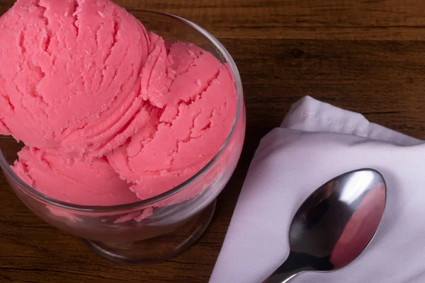 Strawberry flavored ice cream served in a glass bowl Close-up photograph of dessert.