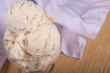 White cream ice cream served in a glass bowl. background with white cloths . Gourmet Photography of Gelato, a popular frozen dessert enjoyed in all countries.