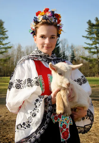 The smiling girl in folk costume with little lamb — Stock Photo, Image