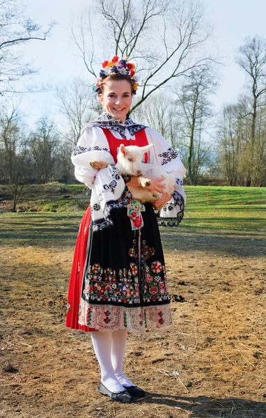La chica sonriente en traje popular con corderito — Foto de Stock