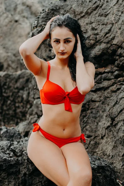 Giovane Donna Posa Con Bikini Rosso Sulle Rocce Una Spiaggia — Foto Stock