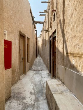 Narrow alley at Souq Waqif, Doha Qatar against blue sky