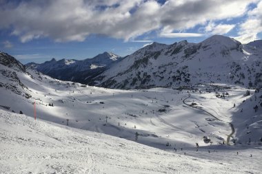 Avusturya 'nın Obertauern kayak bölgesinin panoramik görüntüsü bulutlu mavi gökyüzüne karşı